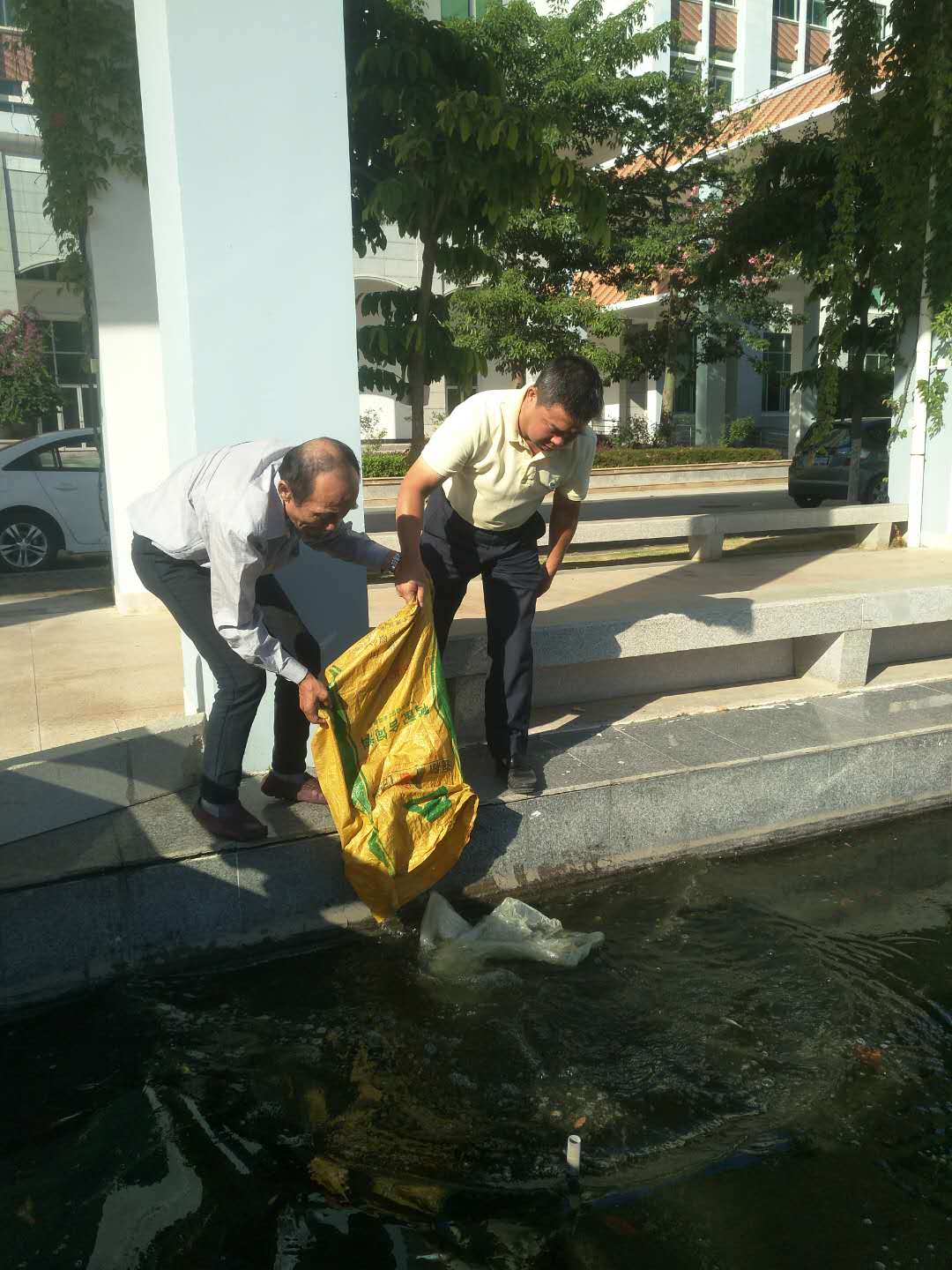 李校长为文泉湖投放鱼苗